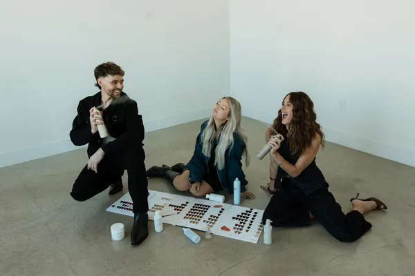 Stylists gathered around hair color swatches on the floor