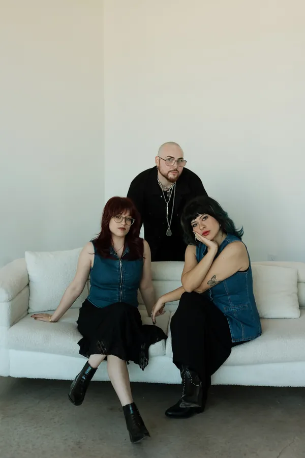 Three stylists relaxing on a white sofa