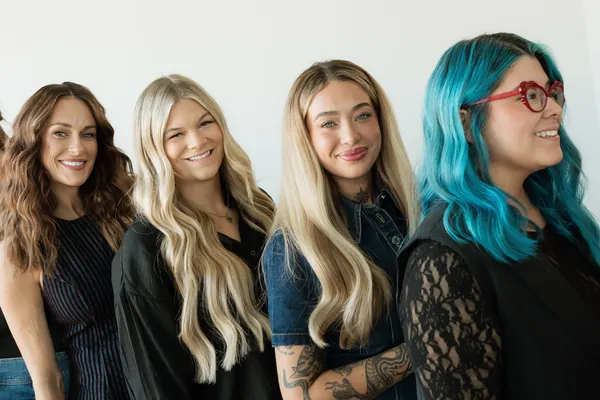 Four stylists smiling side by side